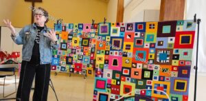 Lorraine teaching with her quilts